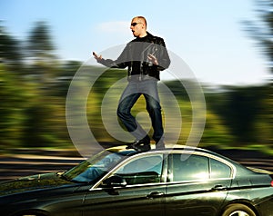 Crazy man standing on moving car