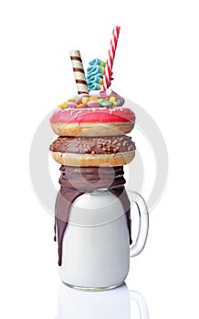 Crazy milk shake with pink and chocolate donuts, color candy and straw in glass jar