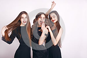 Crazy party time of three beautiful stylish women in elegant evening casual black dress celebrating , having fun, dancing