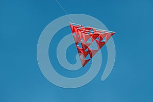 Crazy red tetrahedral kite with blue sky