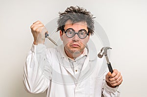 Crazy scientist with hammer and screwdriver