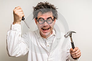 Crazy scientist with hammer and screwdriver