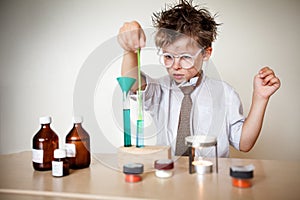 Crazy scientist. Young boy performing experiments