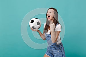 Crazy screaming girl football fan cheer up support favorite team with soccer ball looking aside clenching fist isolated