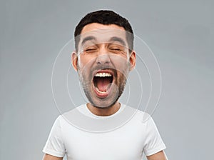 Crazy shouting man in t-shirt over gray background