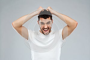 Crazy shouting man in t-shirt over gray background