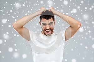 Crazy shouting man in t-shirt over snow background