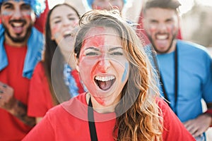 Crazy sport fans screaming while supporting their team - Focus on center girl