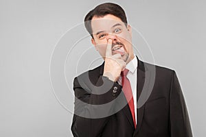 Crazy stupid businessman picking one`s nose