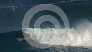 Crazy surfer at a massive wave surfing break called jaws at the north shore of the island of Maui, Hawaii