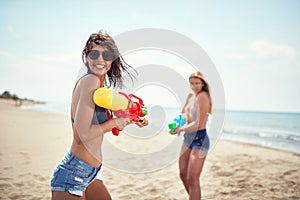 Crazy vacation with happy friends and  fun with water gun at beach. Woman have fun at the beach in summer holiday