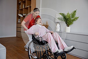 Crazy woman caregiver riding fast elderly woman patient on wheelchair