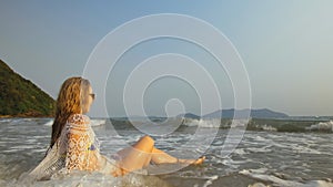 Crazy Woman in a White Tunic on the Beach, near the Stormy Sea. Cheerful Funny Charming Blonde with Wet Curly Hair, in