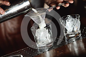 Cream is added to a glass of white Russian cocktail