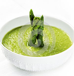 Cream of asparagus soup garnished with green asparagus.