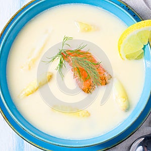 Cream of asparagus soup with salmon rolls and dill