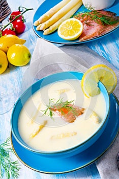Cream of asparagus soup with salmon rolls and dill