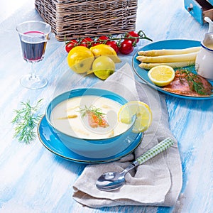 Cream of asparagus soup with salmon rolls and dill