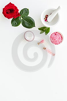 Cream, bath salt, lotion for organic cosmetics with rose flower on white background top view space for text