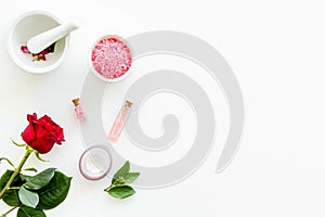 Cream, bath salt, lotion for organic cosmetics with rose flower on white background top view space for text