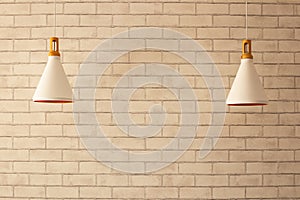 Cream brick wall and two white forms of lamp