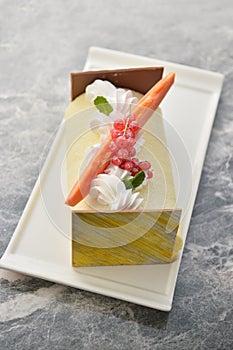 Cream cake with berries on white plate in restaurant