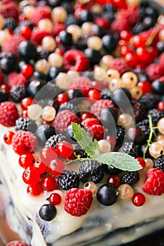 Cream cake with fresh forest and garden berries and mint