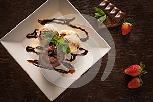 Cream and chocolate ice cream dessert on white square plate