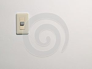 cream-colored light switch mounted on a plain white wall