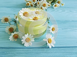 Cream cosmetic daisy chamomile product protection freshness extract on a blue wooden background