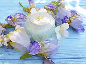 Cream cosmetic flower iris, organic jasmine relaxation treatment product on a wooden background