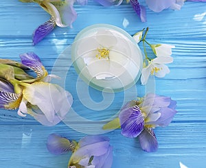 Cream cosmetic flower iris, organic jasmine relaxation treatment product on a wooden background