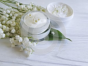 Cream cosmetic lily of the valley relaxation ointment aromatic rustic beauty on a white wooden background