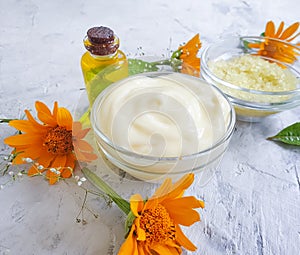 Cream cosmetic moisturizing oil flower calendula healthy relaxation accessories handmade on concrete background