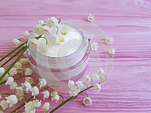 Cream cosmetic organic aromatic flower lily of the valley on pink wooden background