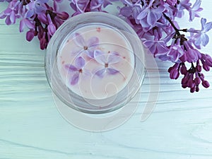 Cream cosmetic scrub lilac flower moisturizer aromatic treatment on white wooden anti aging homemade harmony spa