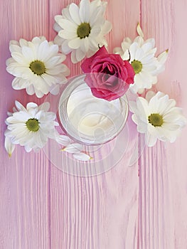 cream cosmetic white flowers on a pink wooden, rose