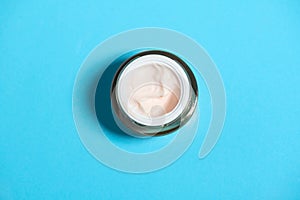 Cream cosmetics top view over blue background. Skin care, moisturizing and nourishing or sunscreen