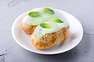 Cream dessert eclair with fresh mint leaves