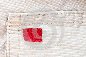 Cream fabric, red label and seam texture background