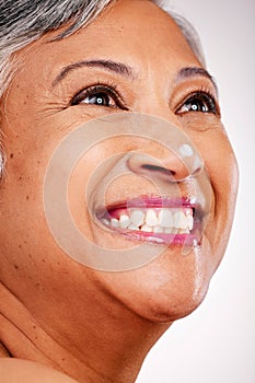 Cream, face and thinking with a mature woman with glow and smile on a white background. Dermatology, moisturizer and