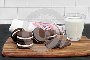Cream filled chocolate cookies, with glass of milk for dunking