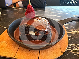 Cream Filled Hot Chocolate Cake Brownie with Strawberry in Pan served at Restaurant. photo