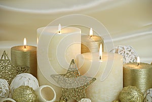 Cream and gold Christmas candles on cream colored background with gold stars