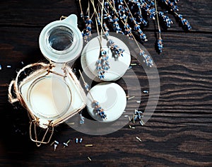 Cream in a jar and dry lavender on a wooden background