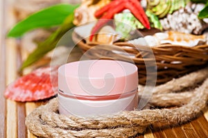 Cream jars on bamboo mat with seashells