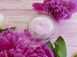 Cream moisturize cosmetic, peony flower rustic on a pink wooden background