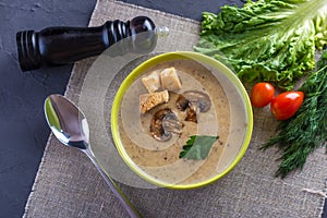Cream of mushroom soup in a green bowl on the table. Healthy vegetarian traditional dish