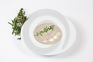 Cream mushroom soup in a white plate on a white background