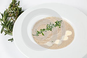 Cream mushroom soup in a white plate on a white background